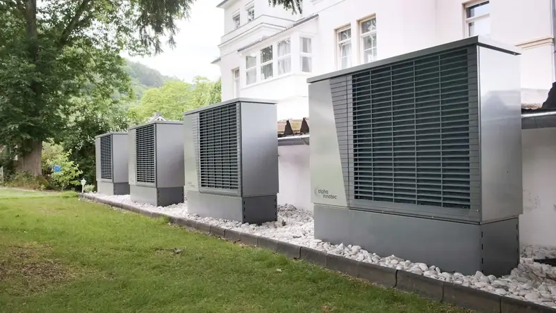 Row of industrial air conditioning condensing units outside a building
